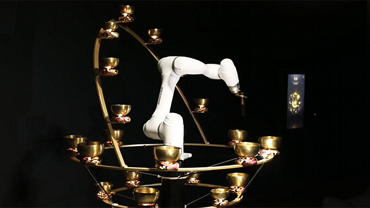 A robot arm playing a ring of brass singing bowls